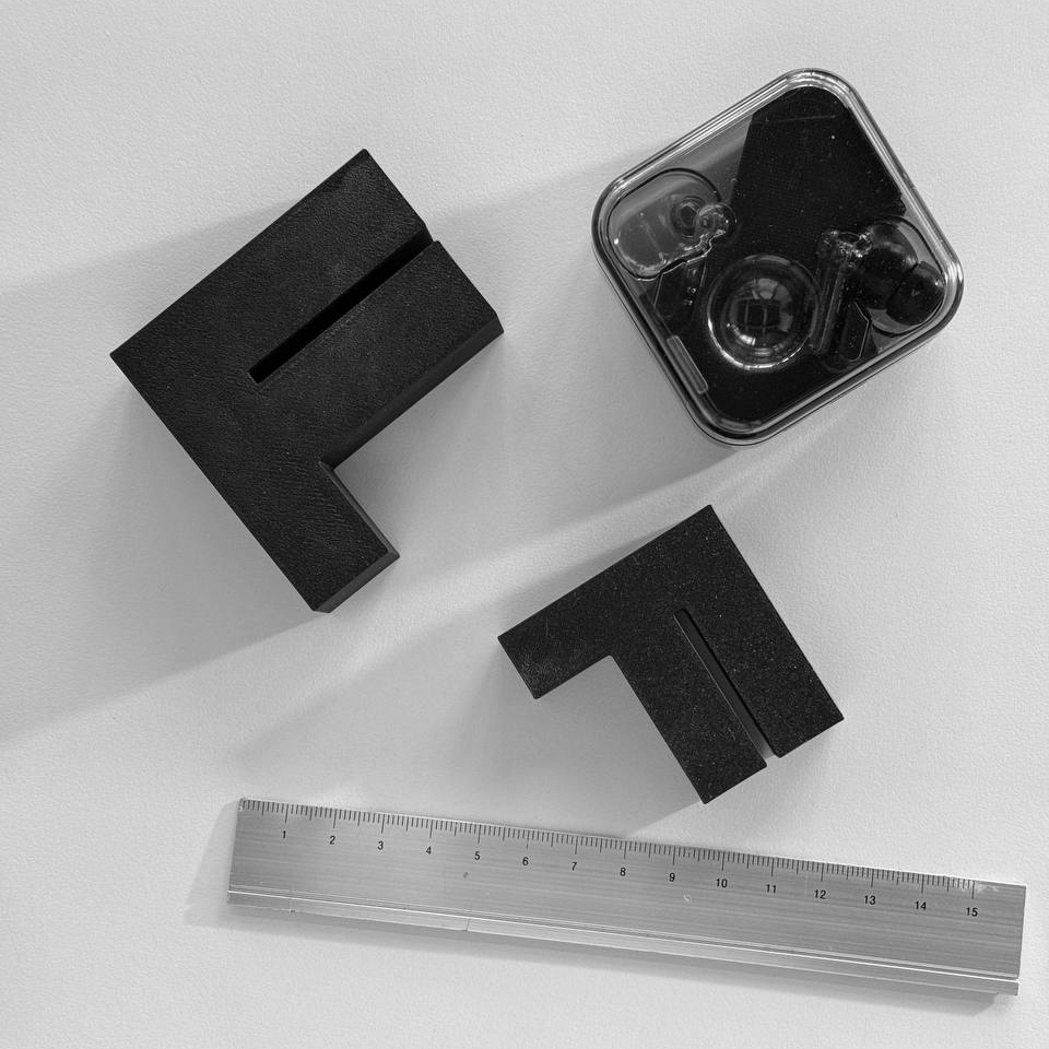 3D-printed FFF logo with a ruler and Nothing earphones for size reference