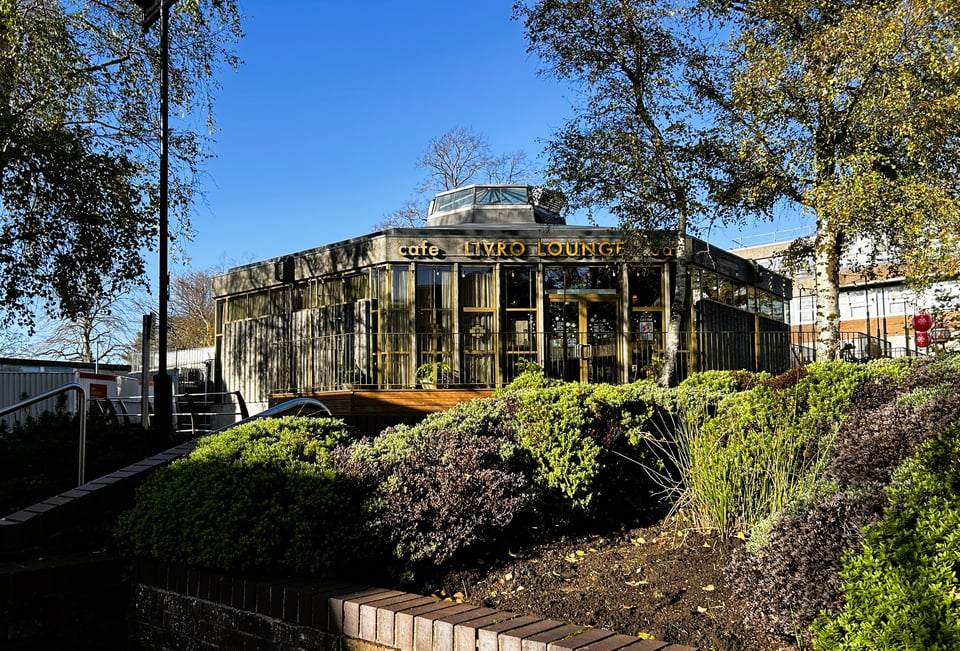 A octagonal building sitting firmly amid some planting.
