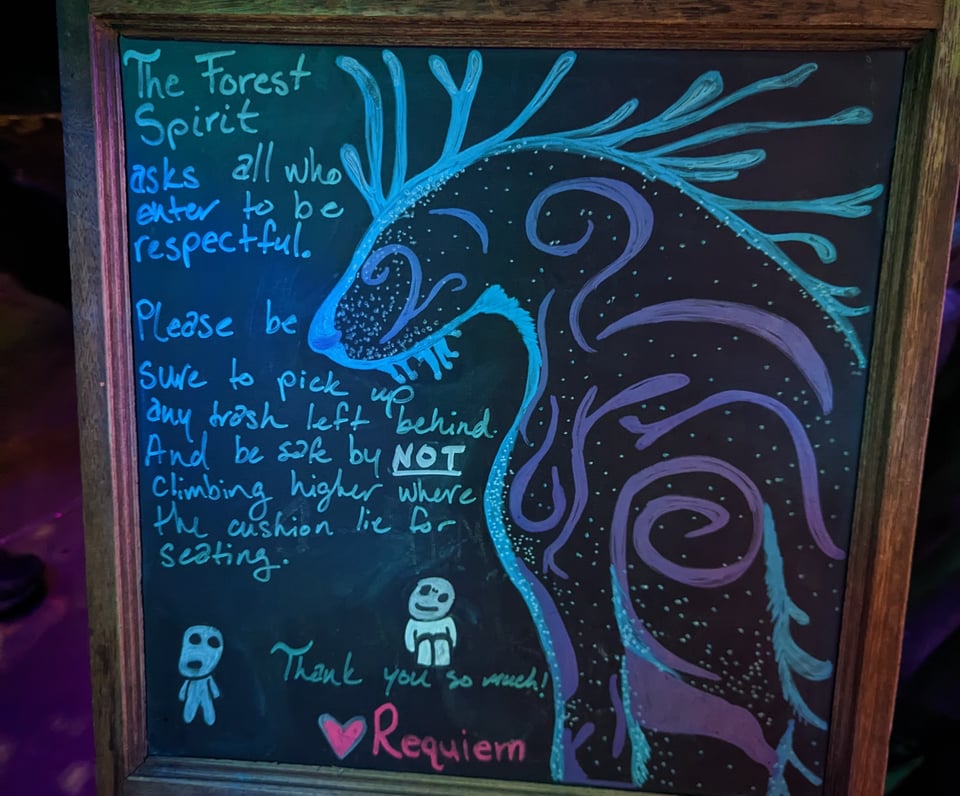A cool chalk billboard shows a mystical forest spirit with some Miyazaki-esque little guys, and it says the forest spirit asks people to be respectful and pick up trash and not to climb onto high surfaces