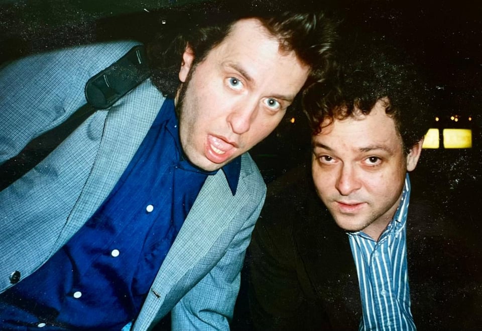 The musicians Mark Mulcahy and Chris Harford lean together in what looks like an off-the-cuff candid photo from 1996.