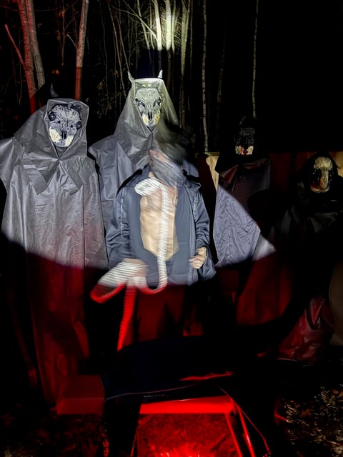 coven of figures lit by a flashlight at night