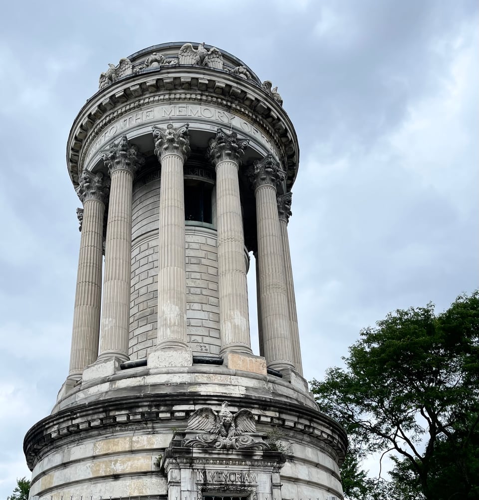 A cylindrical war monument with a ring of pillars.