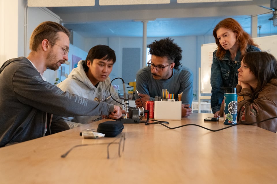 Elijah showing people how to use a soldering iron.