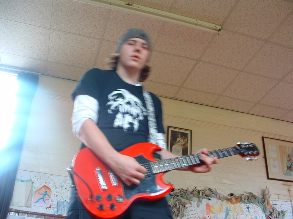 The author as a teenager playing guitar in a parochial building