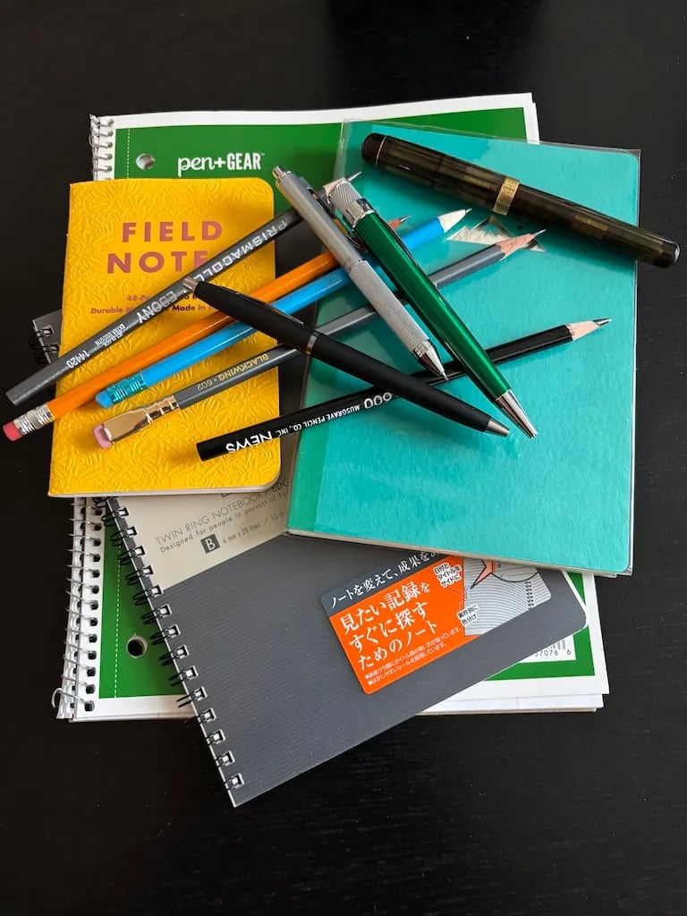 a collection of notebooks and pens to support self learning