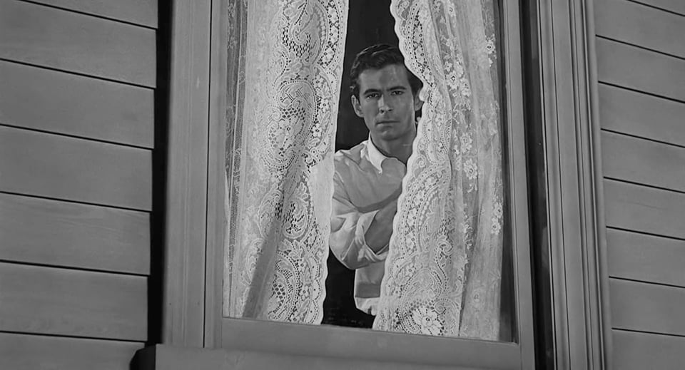 A still from the movie Psycho (1960). A man glances out of a window.