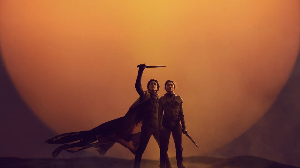 Promotional image from Dune showing two people holding swords in the desert