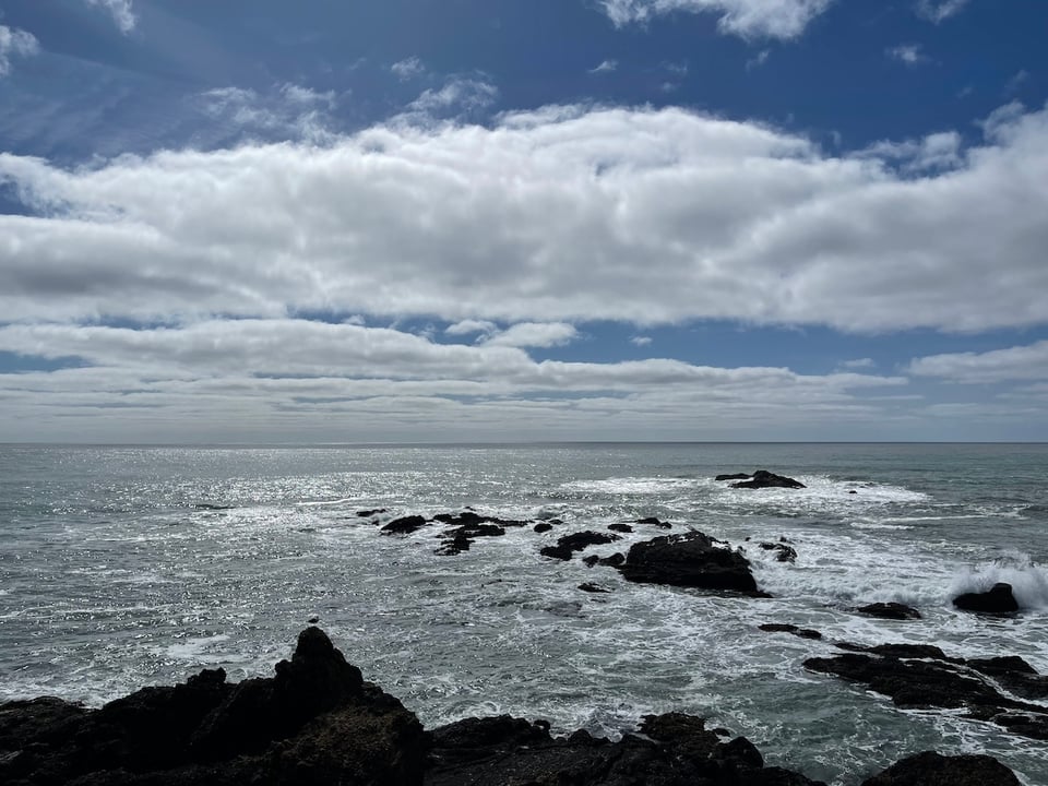 a rocky shore with a cloudy sky