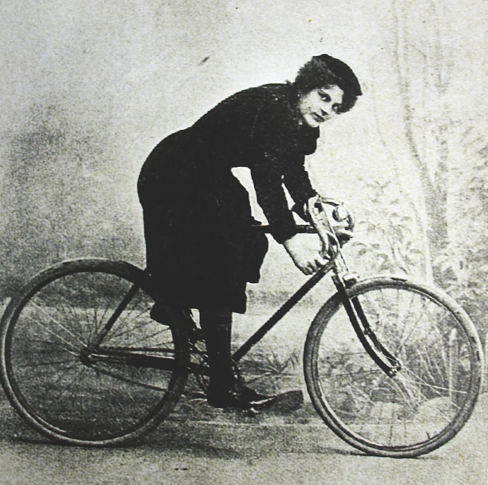 Foto de una mujer en 1898 subida en una bicicleta, con bombachos.