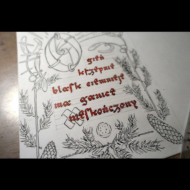 zdjęcie pracy w toku, kaligrafia czerwonym tuszem i rysunek czarnym tuszem