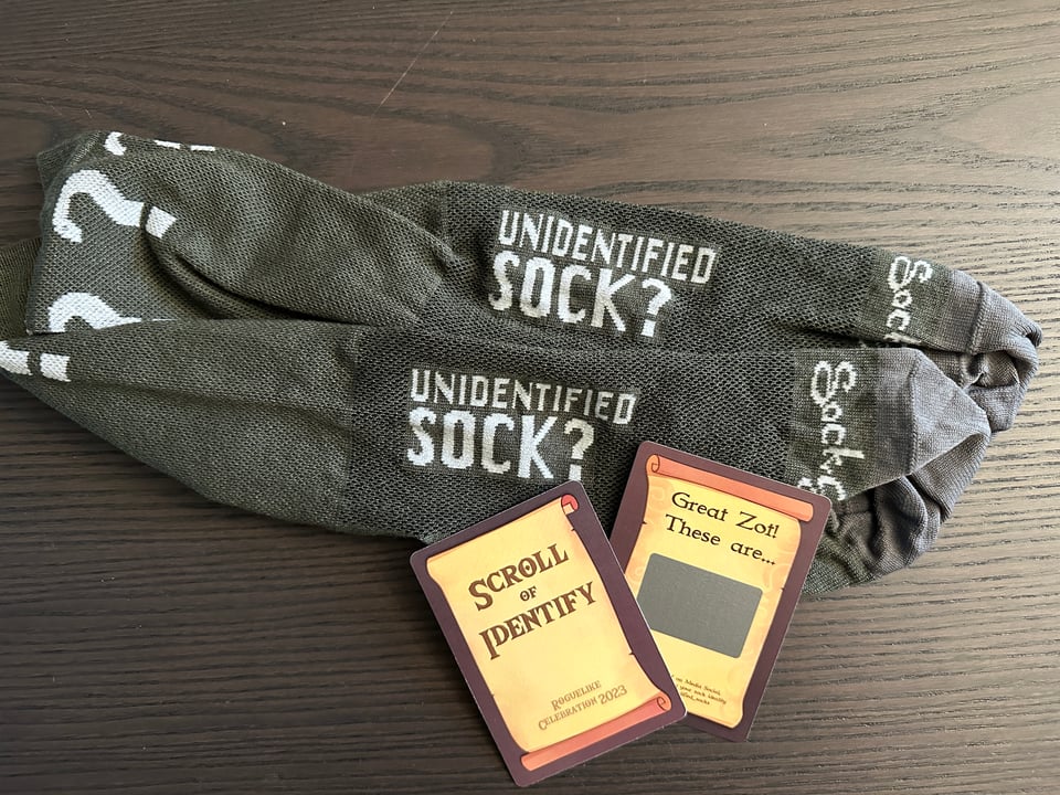 Grey 'Unidentified' Socks with question marks on the cuff, and scratch-off 'Scrolls of Identify' cards