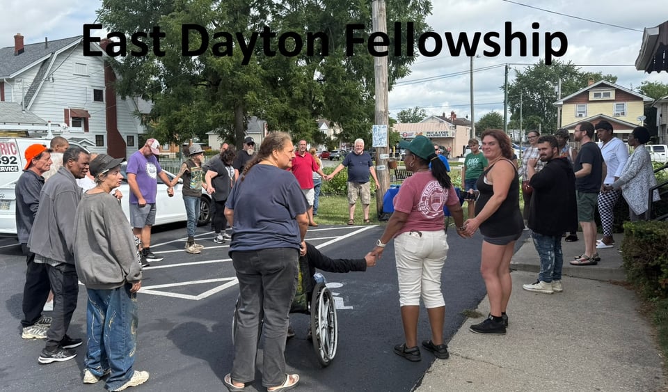 A group of people praying outside before the church's Friday ministries.