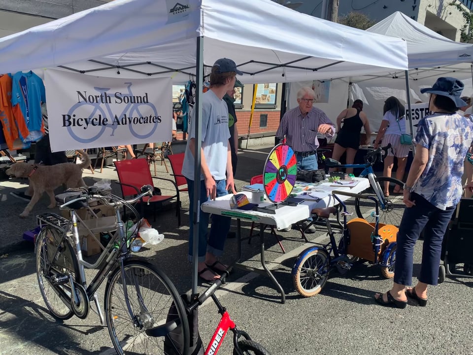 people at a table at a market talking to others