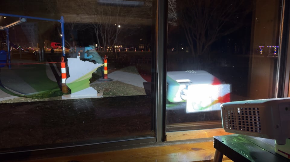 Projector inside a building projecting onto Minnesota shape outside