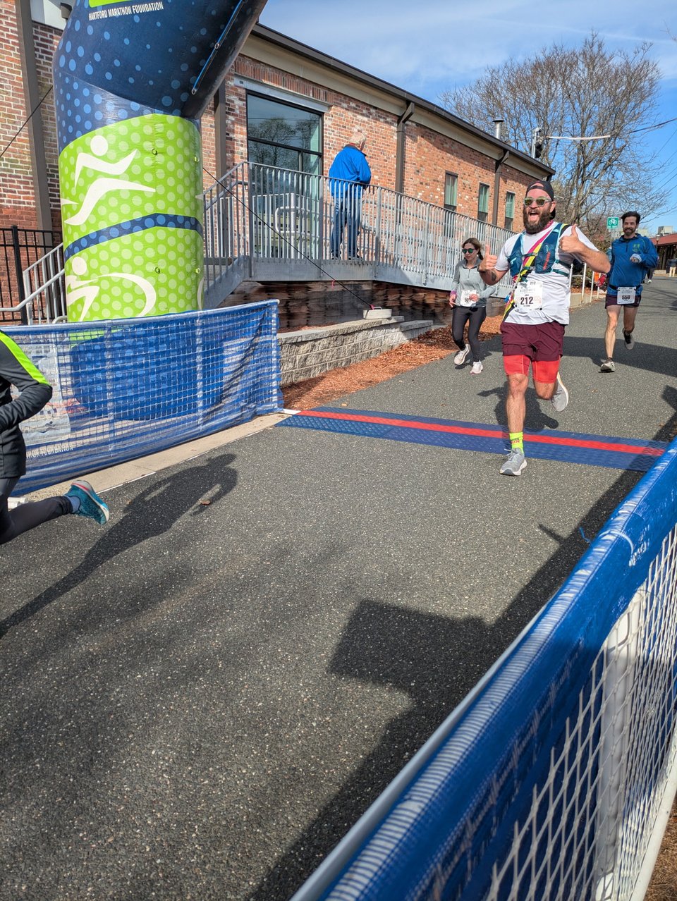 The finish line at the Western Mass 10 Miler. I have just passed the finish with elbows out and thumbs up.