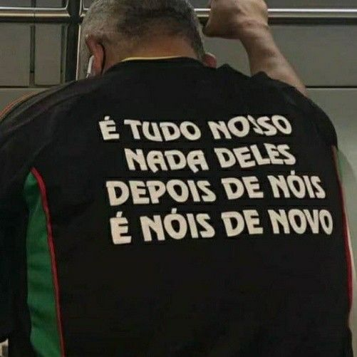 Imagem de homem de costas vestindo uma camiseta preta com o texto: É TUDO NOSSO
NADA DELES
DEPOIS DE NÓIS
É NÓIS DE NOVO
