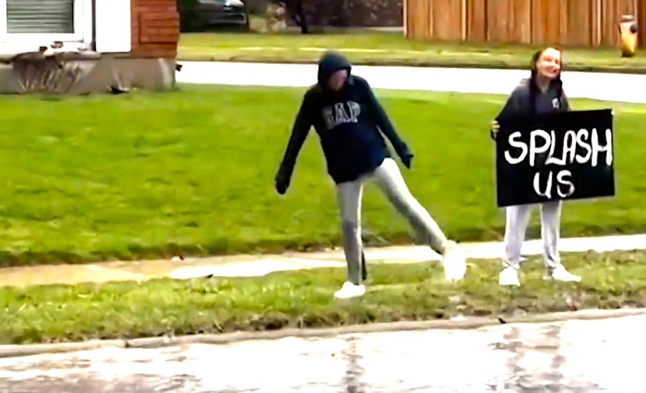 In this screencap taken from the CBC News website, Lillie and Harper O’Reilly shake off the rain-soaked drenching they’ve just received from a passing motorist in St. Thomas, Ontario. The video taken by their mom has been viewed on TikTok 10 million times.