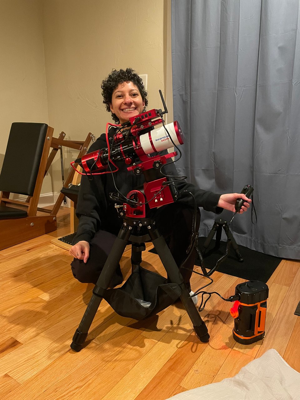 a photo of me with my new astrophotography rig (and a Pilates baby chair in the background)