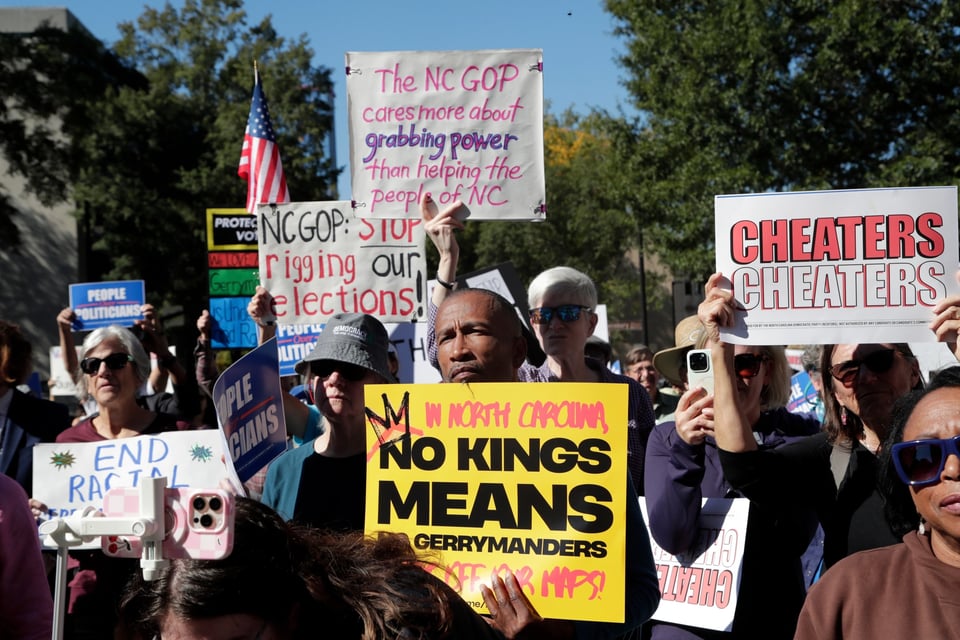 Demonstrators hold signs during a rally protesting a proposed election redistricting map Tuesday, Oct. 21, 2025, in Raleigh, N.C. | Chris Seward/AP Photo