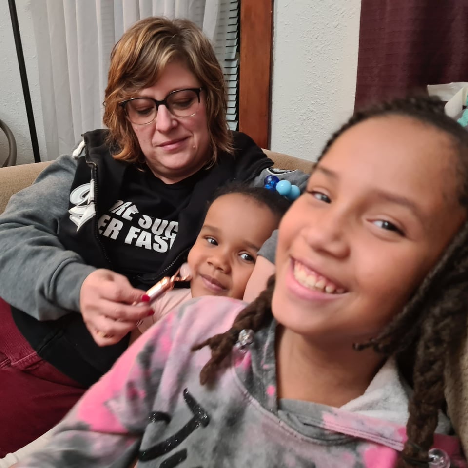 Hope massaging the face of one of my nieces while the other looks at the camera