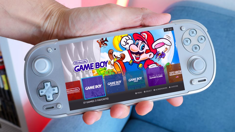 hand holding a white retro gaming handheld