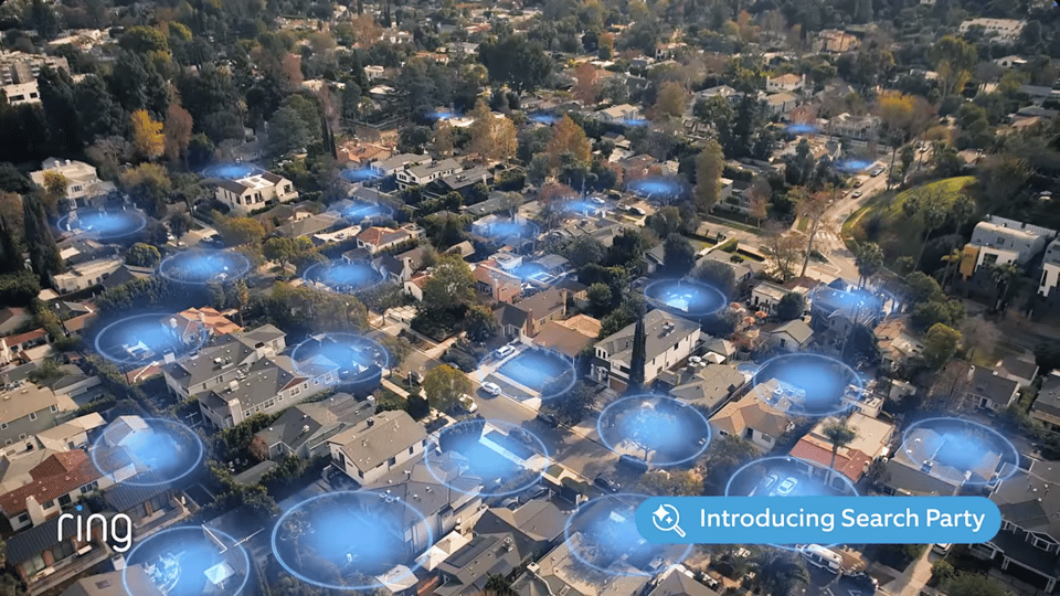 Aerial photo of a suburban neighborhood filled with blue circles showing the range of Amazon Ring surveillance cameras. Text at bottom reads "ring" and "Introducing Search Party".