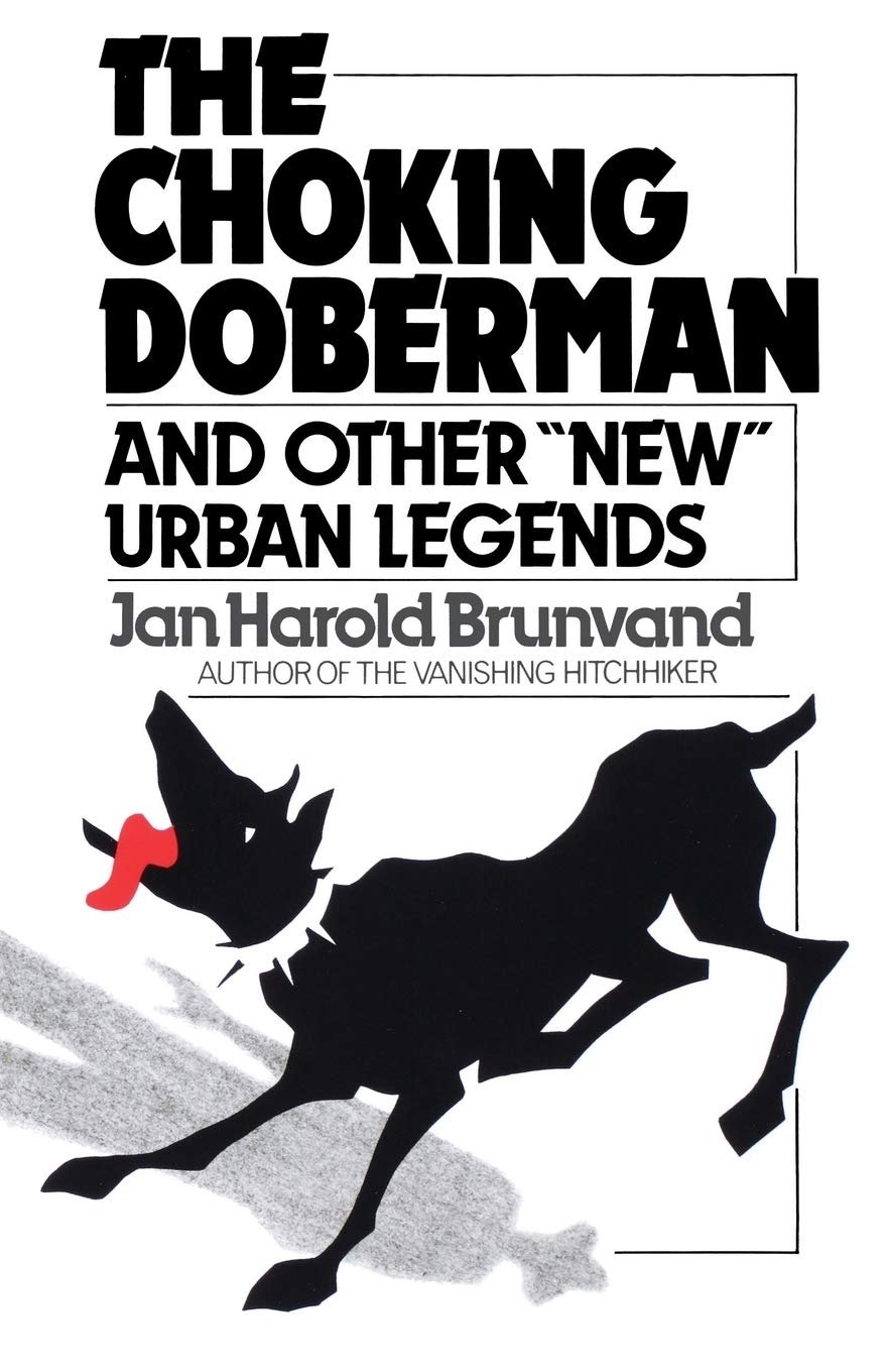 Cover of the book, "The Choking Doberman." Image: a stark illustration of a black attack dog with a spiked collar choking on something, with a red, lolling tounge. The long shadow of a man in a hat falls over the dog. Text: The Choking Doberman, an other "new" urban legends. Jan Harold Brunvand, author of The Vanishing Hitchhiker.