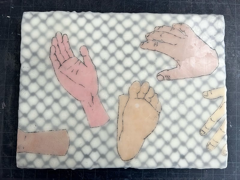 painting of severed hands and feet over a keffiyeh pattern. In progress.