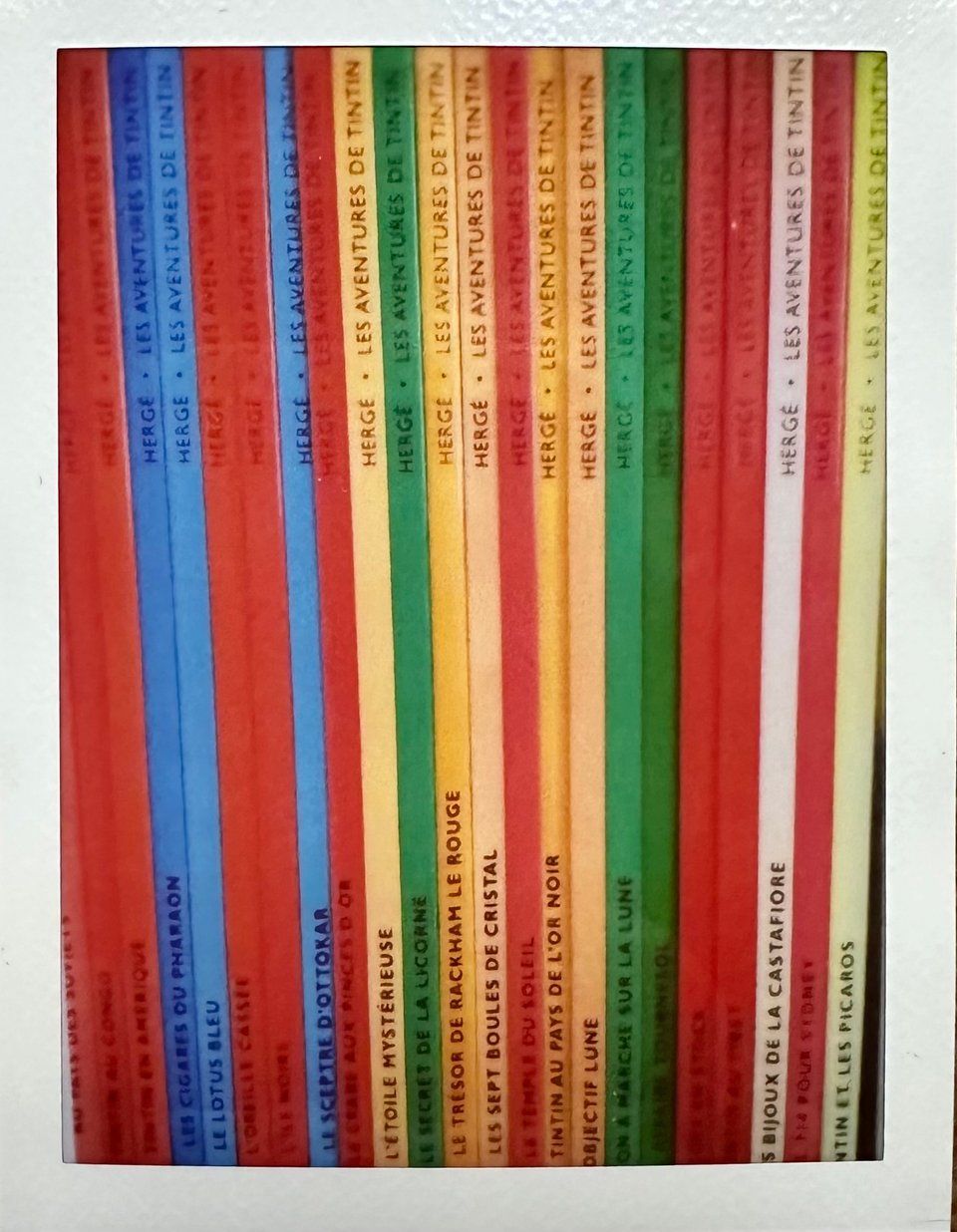 Photo of the spines of ~20 Tintin albums, in French