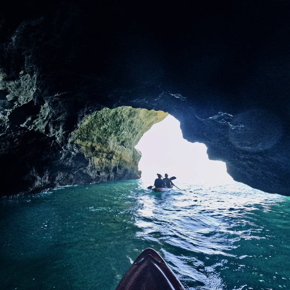 Photo taken from a kayak on the sea, making its way out of a cave