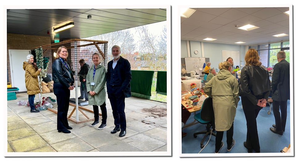 Visitors from Wandsworth Council on balcony looking at camouflage net under construction, and in sewing room examining work in progress