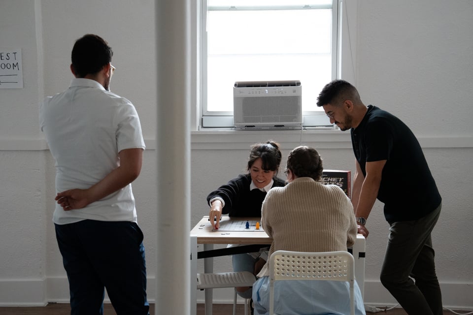 More people at a table playing Ricochet Robots.