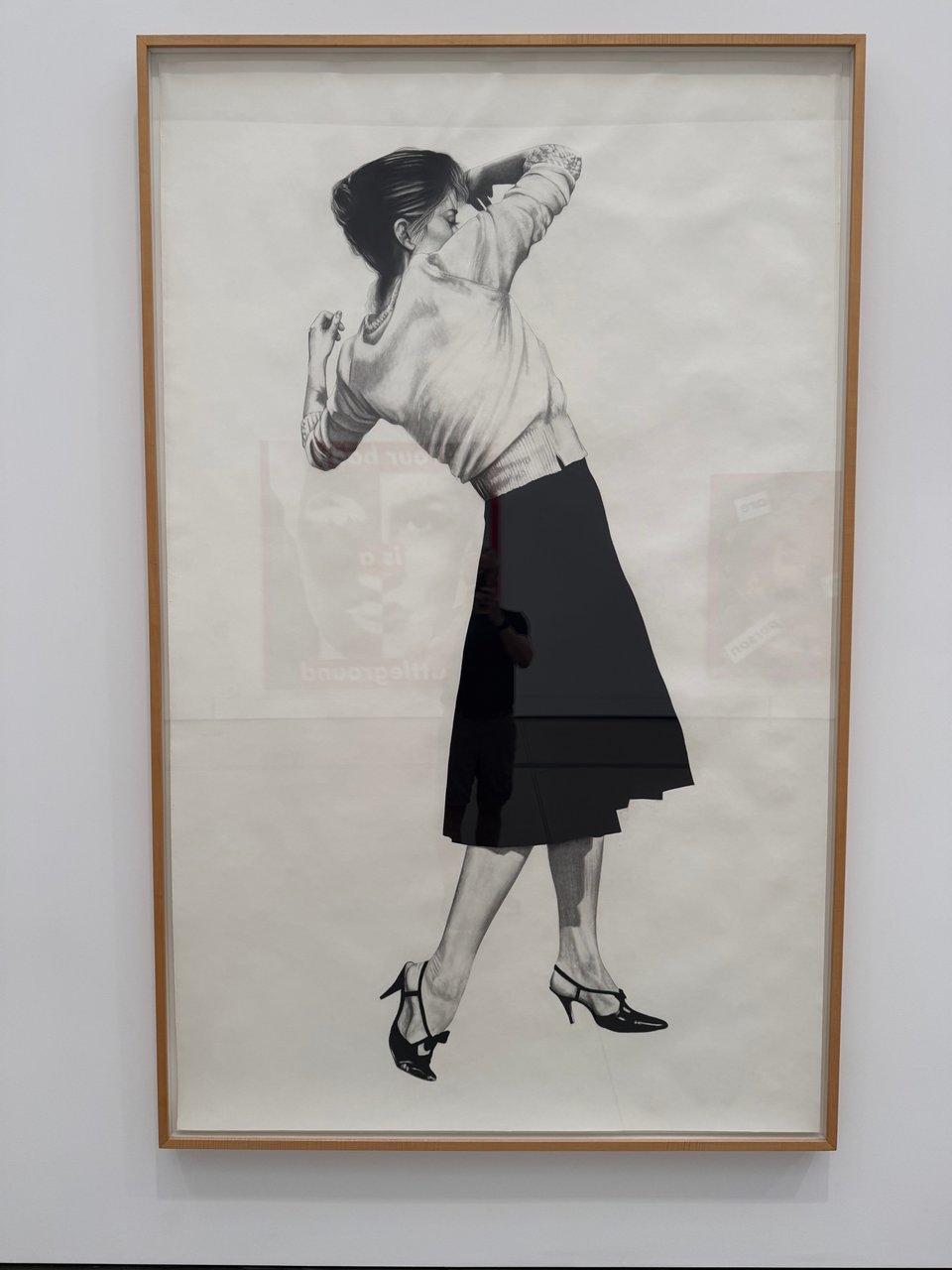 photo of framed museum piece of Robert Longo's "Untitled (Men in the Cities: Ellen)," which, per the museum's site, "shows a young woman in a moment of ambiguity, with a full and purposeful gesture yet unmoored to any definition beyond her stylish heels, proper blouse, and designer skirt."