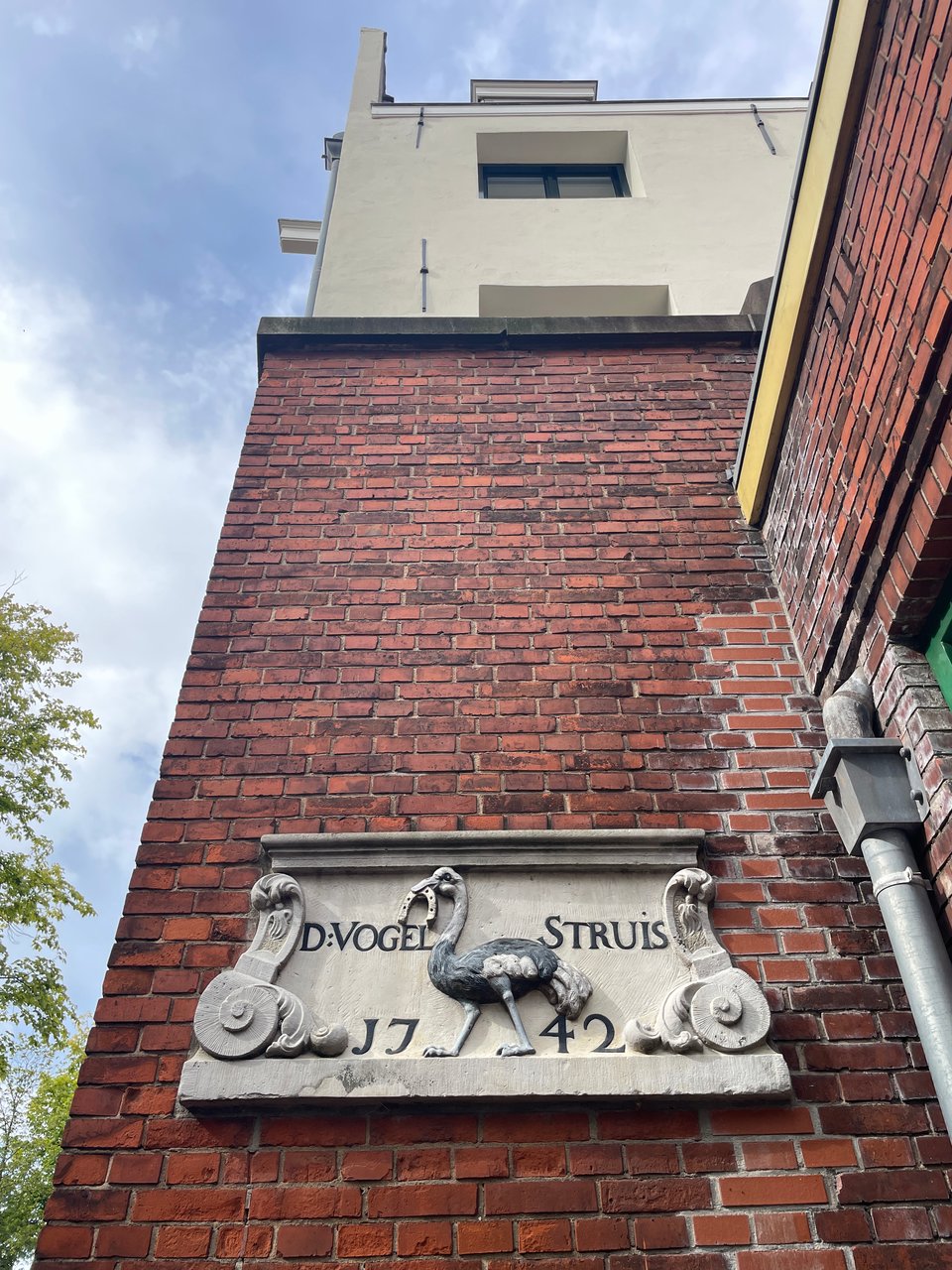 A stone plaque on a building in central amsterdam shows an ostrich with a horseshoe in it's beak. It says "VogelStruis 1742"