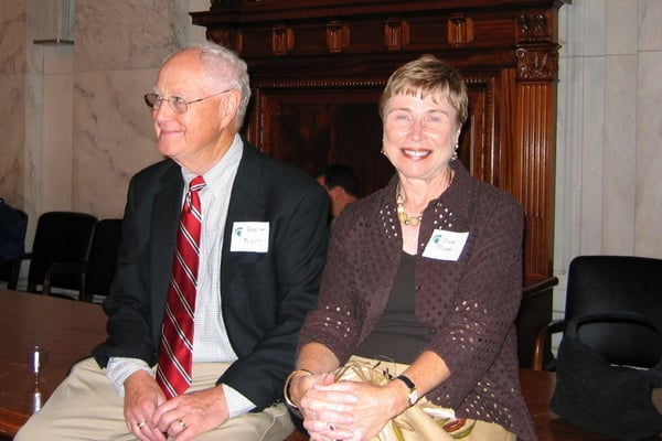 A man and woman sit together and smile at an event.