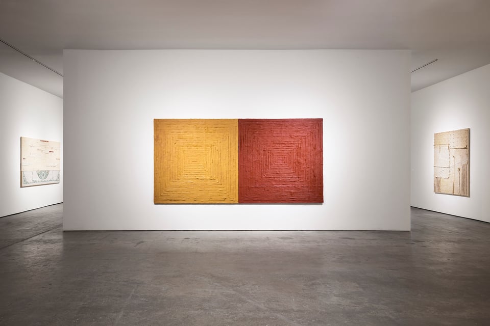 An installation view of Harmony Hammond's exhibition at SITE SANTA FE. this is a frontal view of a dipytch-like painting composed of highly textured, "bandaged" canvases, one mustard and one rust-red.