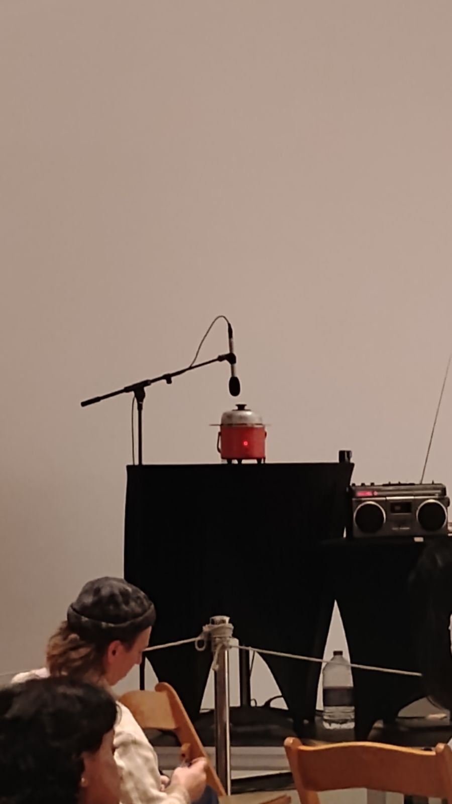 a red rice cooker on a table with a mic pointed at it as part of UMI HSU’S performance at LACMA