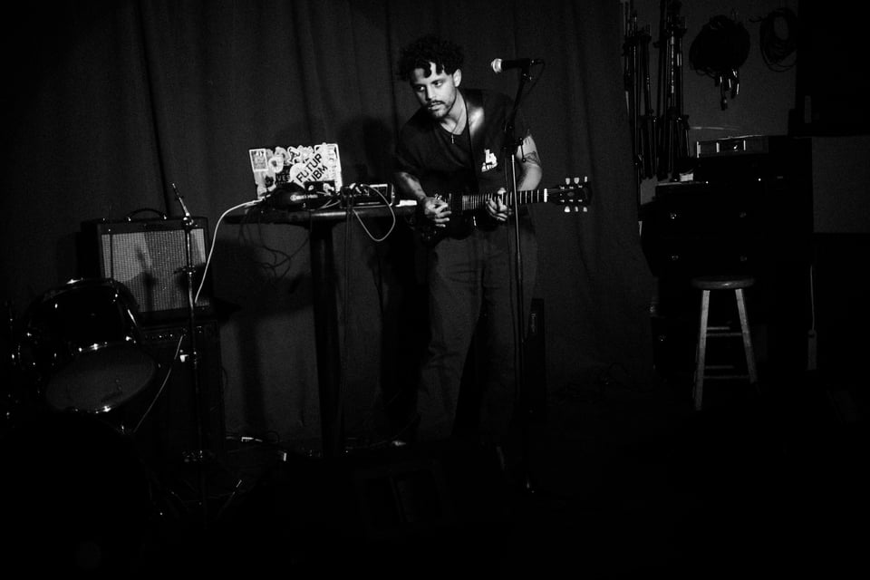 Ghost Down performs at Cobra Club on Sunday, May 18th, 2025. They play guitar while watching an ableton live set scroll on their laptop.