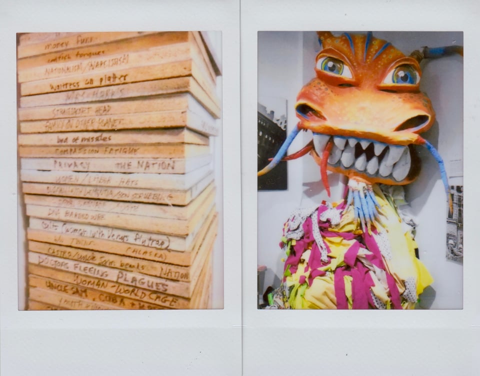 two Instax photos: left, a stack of linocuts against a white wall; right, a parade-dragon head mounted on a wall above the purple & yellow costume that the participants would wear