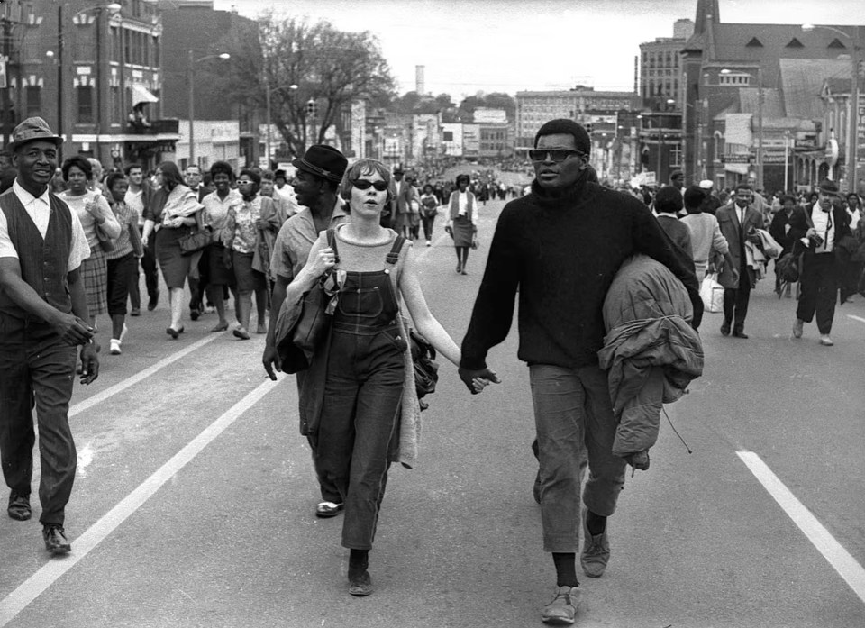 a naturalistic black and white photo of an extremely cool-looking couple marching on montgomery