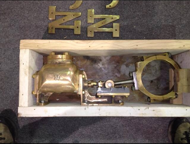 The brass pump inside a wooden frame