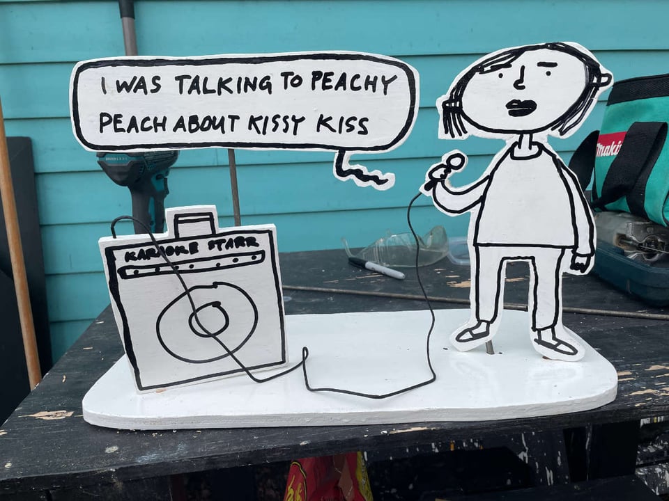 diorama of woman singing a Pixies song at karaoke