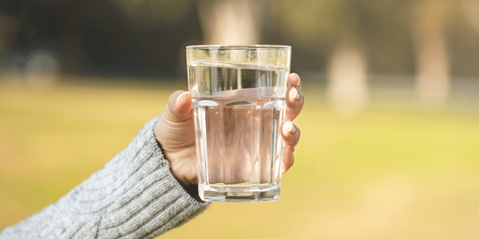 A person holding a glass of water.