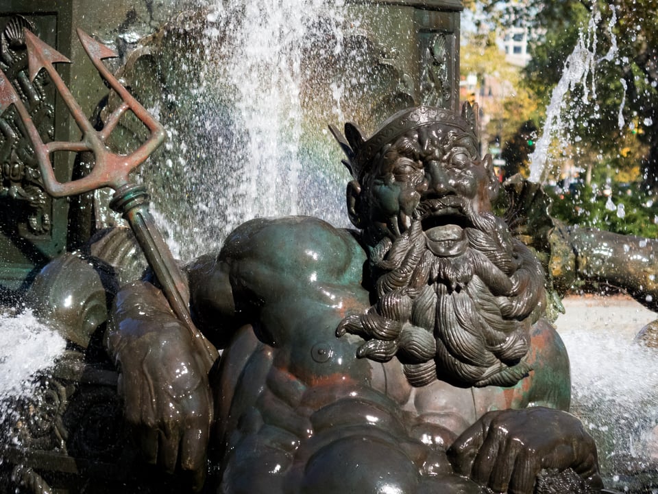 A statue of Poseidon in a fountain.