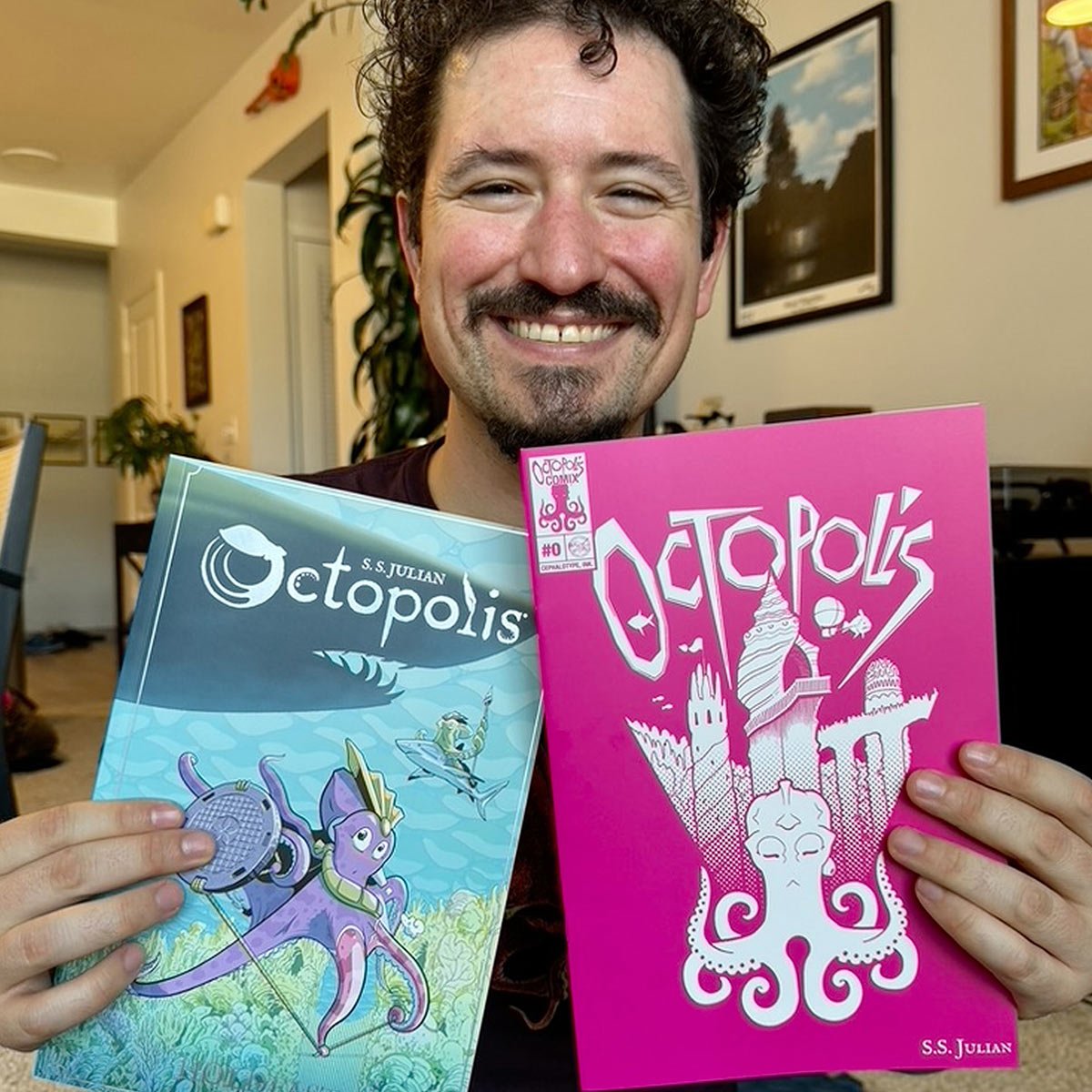 Sam Julian holding up his comics Octopolis