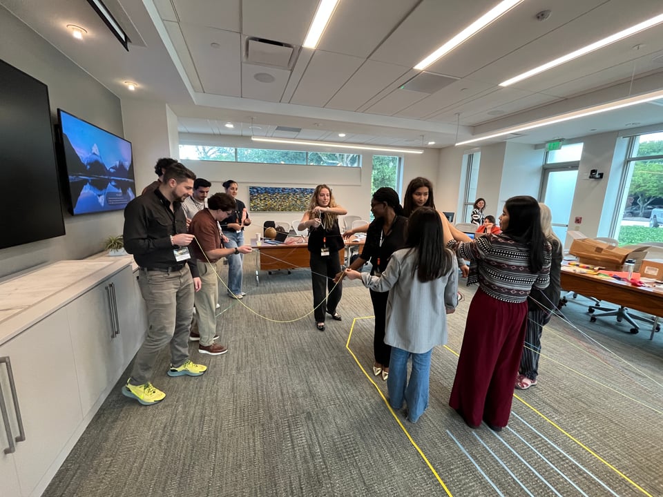 photo of people holding string and standing in a boat shape at a data workshop