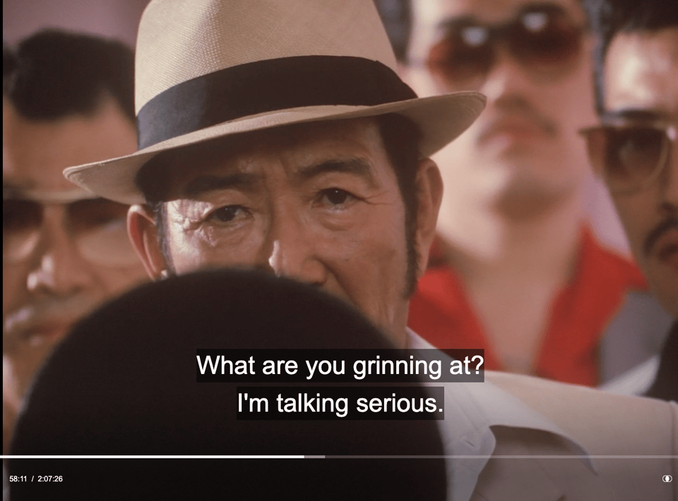 screen shot with english caption "What are you grinning at? I'm talking serious."