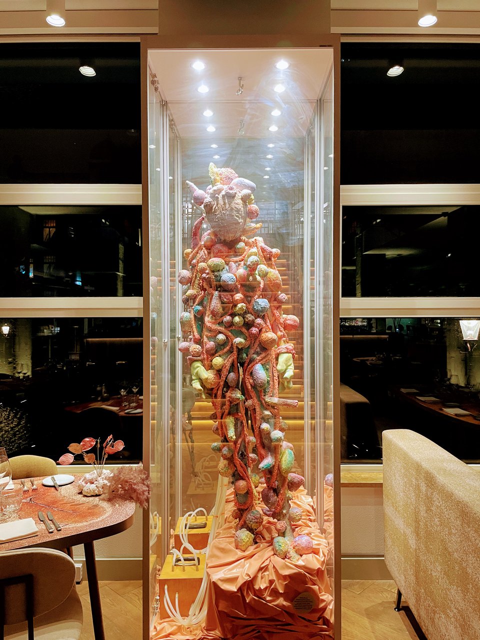A humanoid sculpture in a glass enclosure.