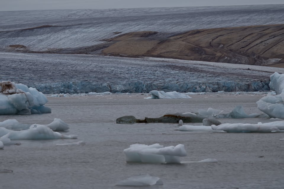 glacial terminus into water with ice bergs
