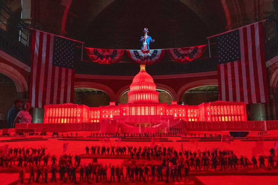 Uncle Sam, played by Dana Watkins, welcomes players to “Fight for America,” an interactive tactical tabletop game staged in London that explores the Jan. 6, 2021, assault on the U.S. Capitol using a 1:64 scale 3-D printed Capitol and more than 10,000 hand-painted figures. (Peter van Agtmael/Magnum Photos for The Washington Post)